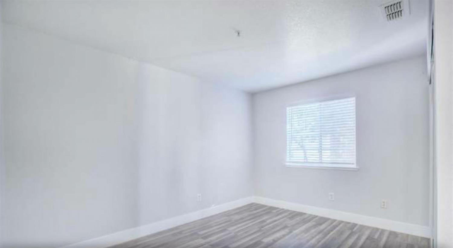 8020 Walerga Road, Unit 1147 Antelope, CA 95843 - Photo 14 of 20 a view of an empty room with wooden floor and a window