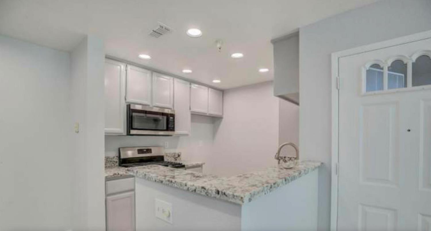 8020 Walerga Road, Unit 1147 Antelope, CA 95843 - Photo 3 of 20 a kitchen with a sink a microwave a stove and cabinets