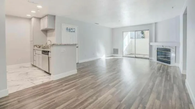 a view of a kitchen with wooden floor and a window