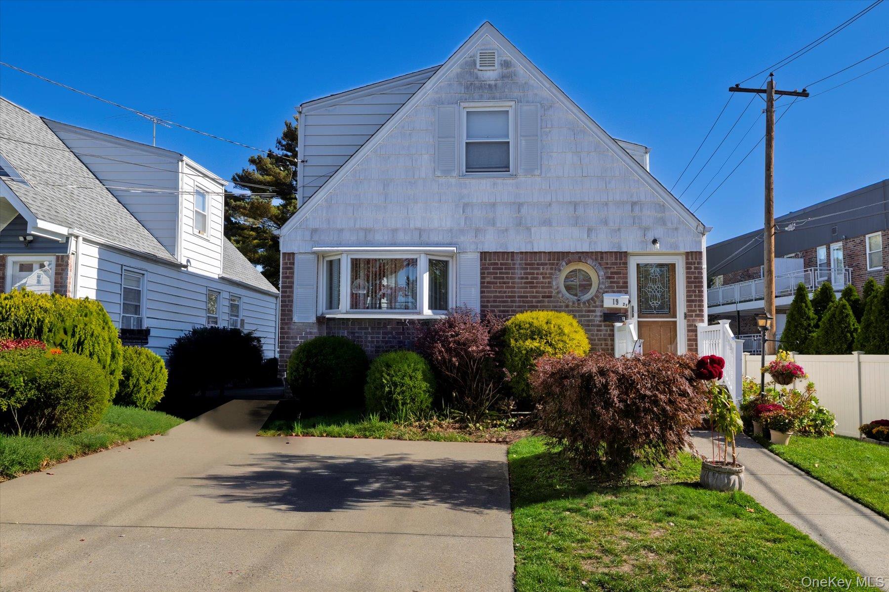 19 Daley Place, Unit 2 Lynbrook, NY 11563 - Photo 1 of 1 a front view of a house with a yard and potted plants