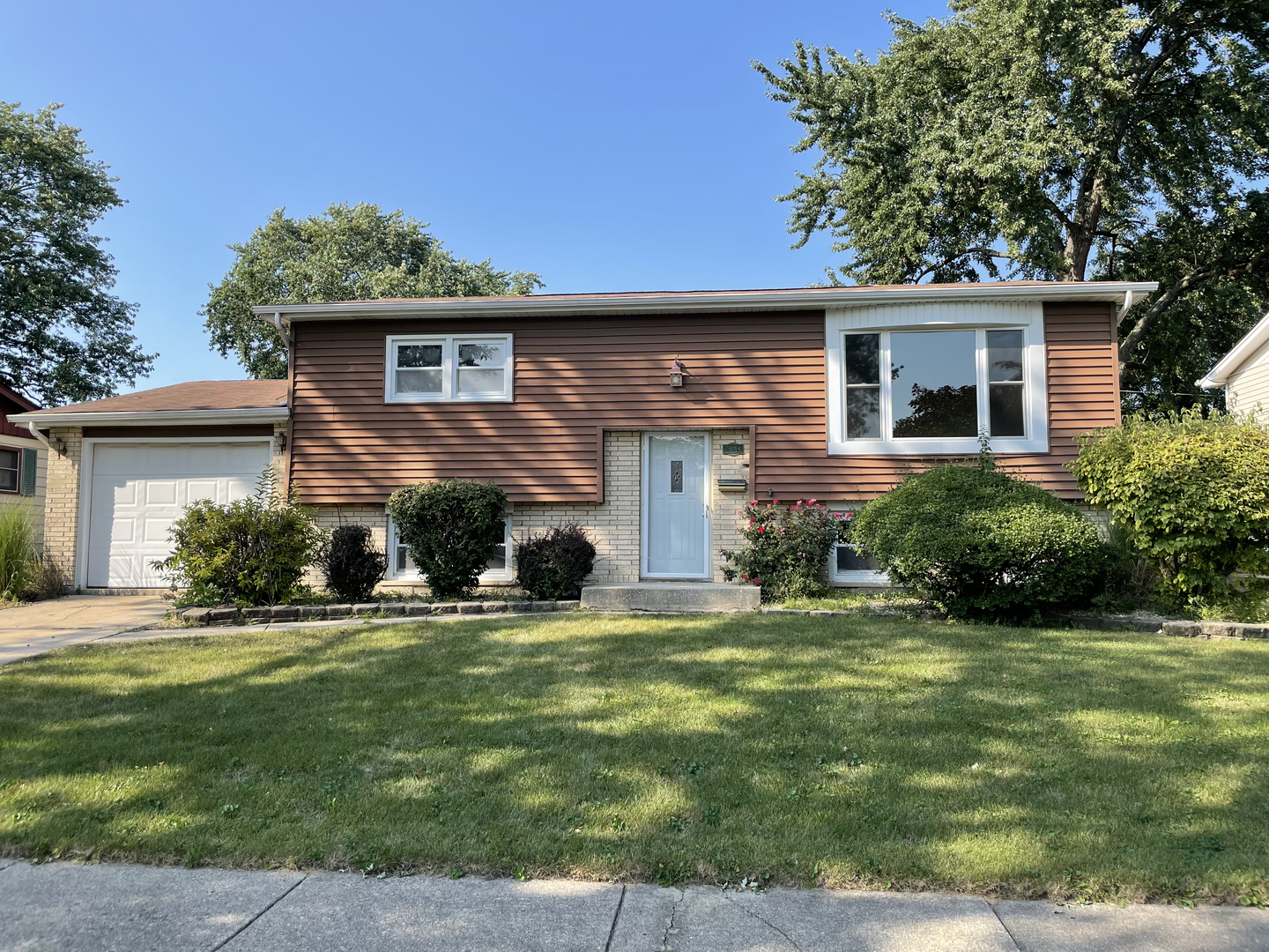a view of a house with a yard porch and a tree