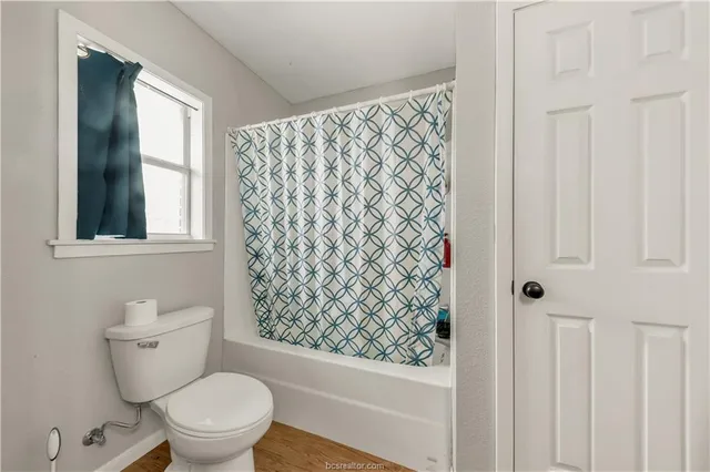 a white toilet sitting next to a shower curtain