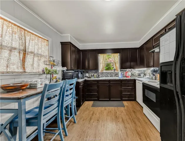 a kitchen with stainless steel appliances kitchen island granite countertop a stove a sink and a refrigerator