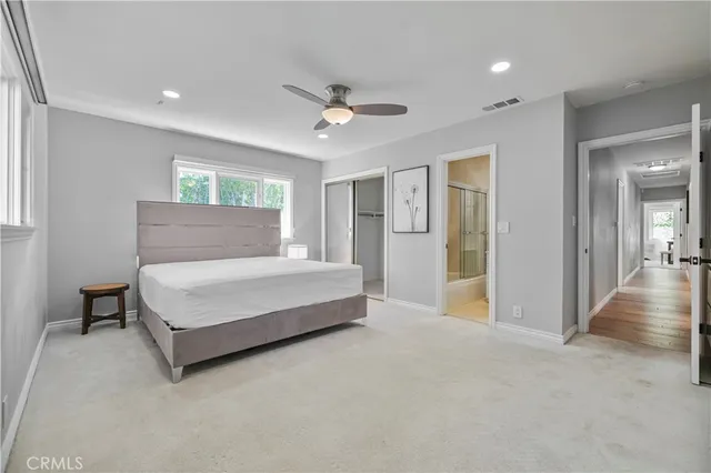 a spacious bedroom with a bed and ceiling fan
