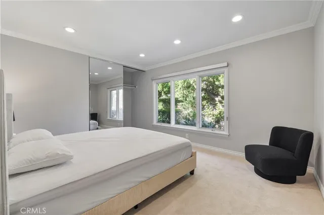 a bedroom with a bed and a couch with window