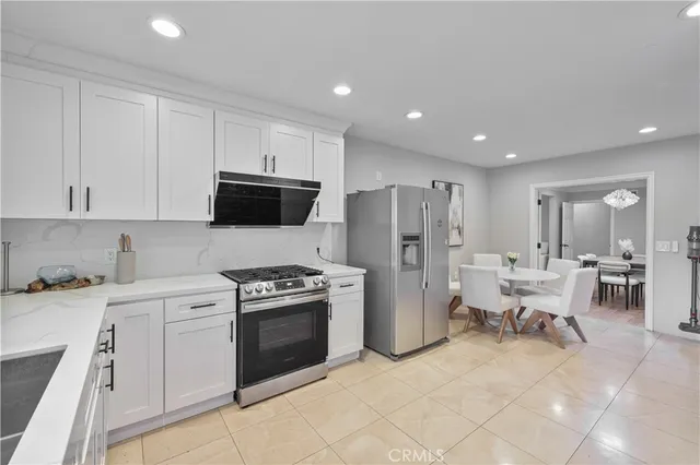 a kitchen with white cabinets and stainless steel appliances