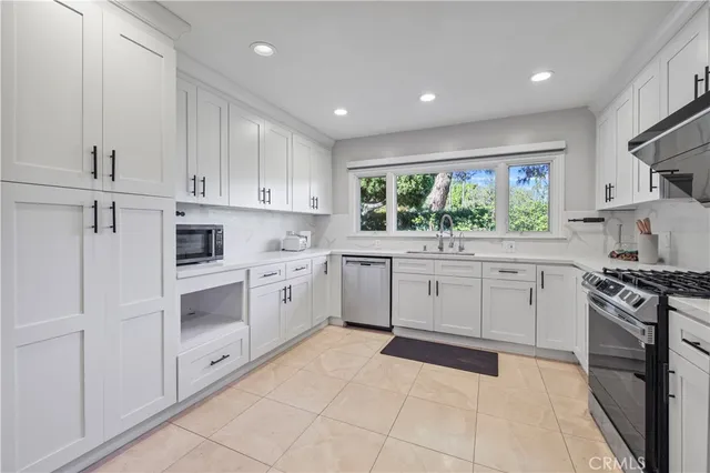 a kitchen with white cabinets and white appliances