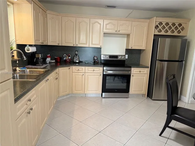 a kitchen with cabinets stainless steel appliances and a sink