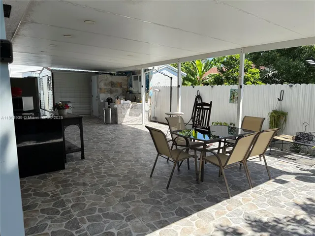 a dining room with furniture and a floor to ceiling window