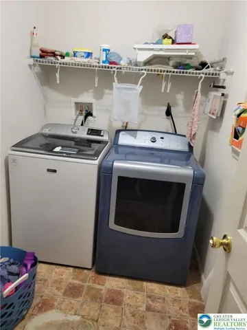 a bed sitting in a bedroom next to a flat screen tv and a window