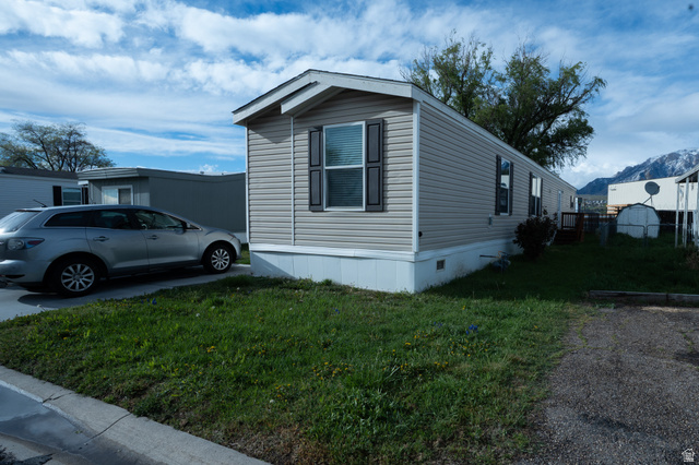 2491 Highway 89, Unit 111 Pleasant View, UT 84404 - Photo 2 of 20 View of home's exterior featuring a lawn and a mountain view