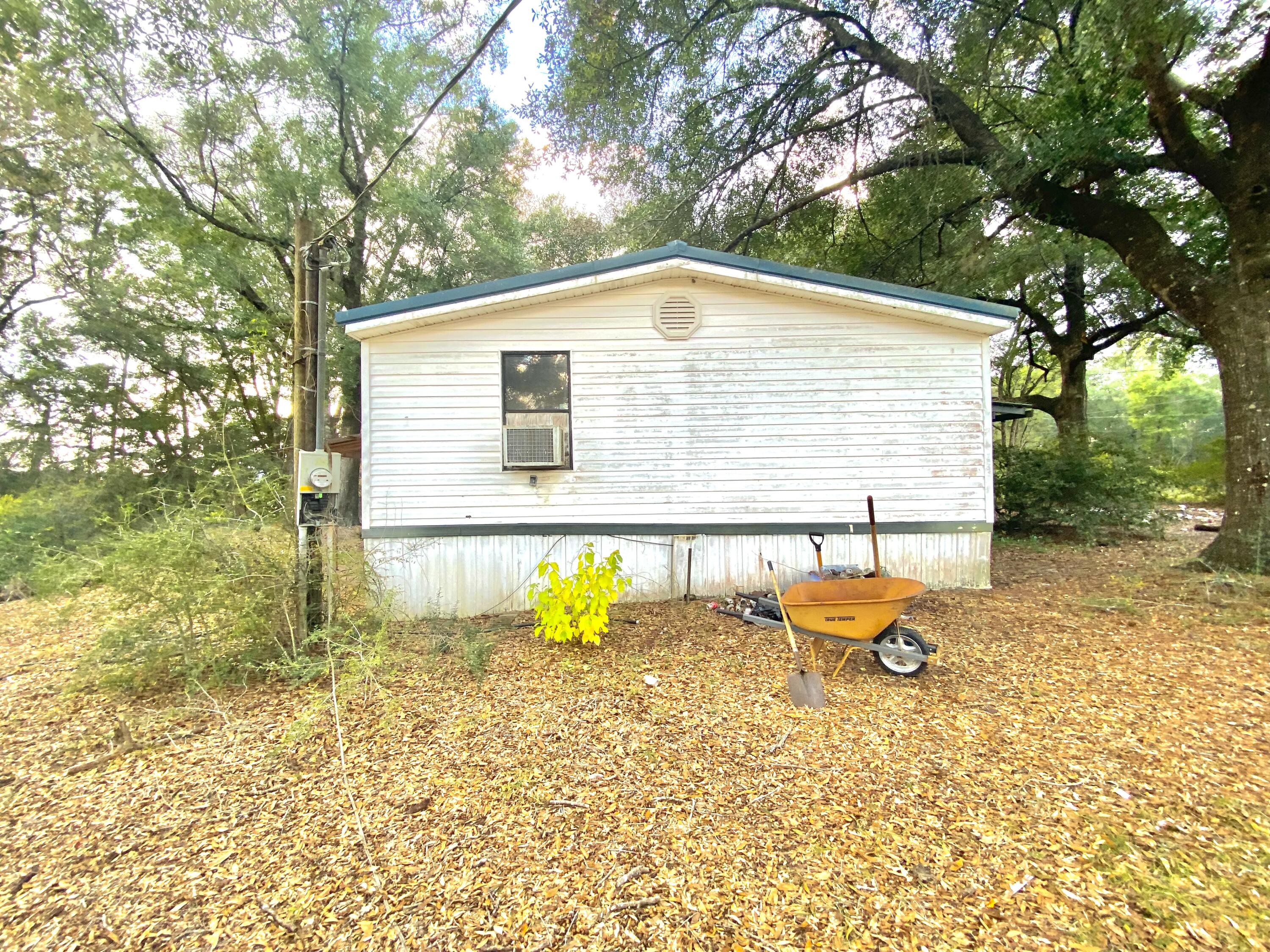 4977 Douglas Ferry Road Caryville, FL 32427 - Photo 4 of 11 a backyard of a house with table and chairs