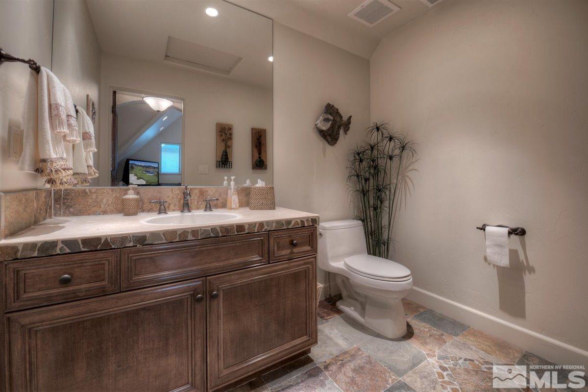 5915 Chambery Circle Reno, NV 89511 - Photo 29 of 40 a bathroom with a granite countertop toilet a sink and a mirror