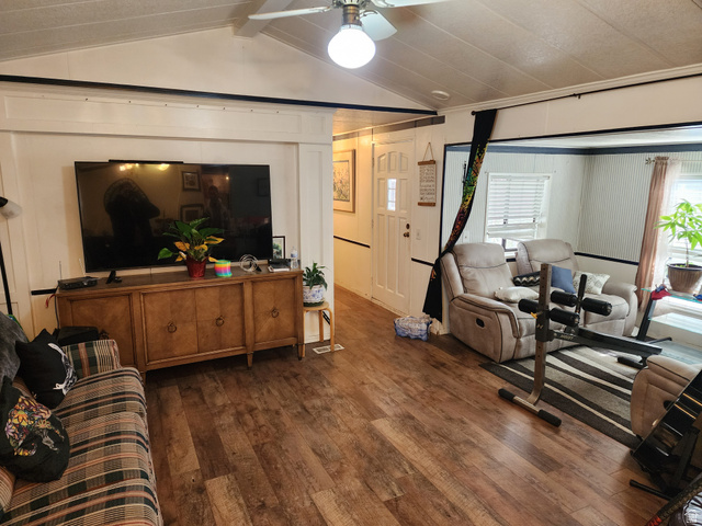 11362 Crescent Park Way, Unit 8 Sandy, UT 84070 - Photo 4 of 20 Living room featuring dark wood-style floors, a ceiling fan, beamed ceiling, and a decorative wall