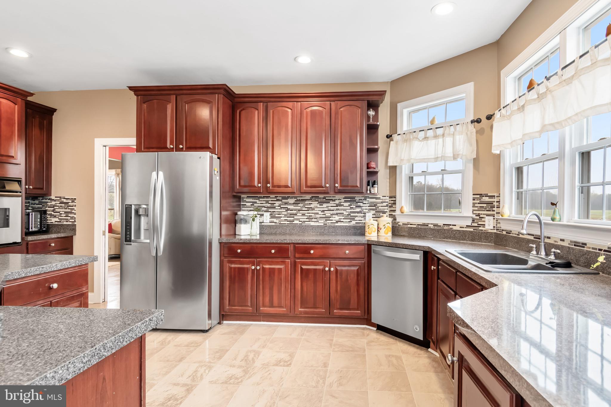 5855 Bethlehem Road Preston, MD 21655 - Photo 23 of 43 a kitchen with stainless steel appliances granite countertop a refrigerator a sink a stove a washer dryer and cabinets