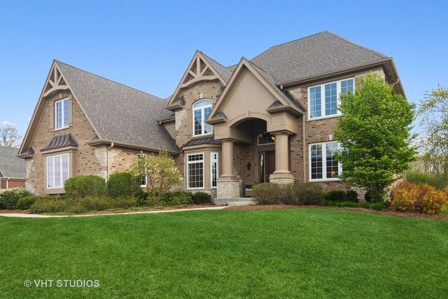 a front view of a house with a yard and trees