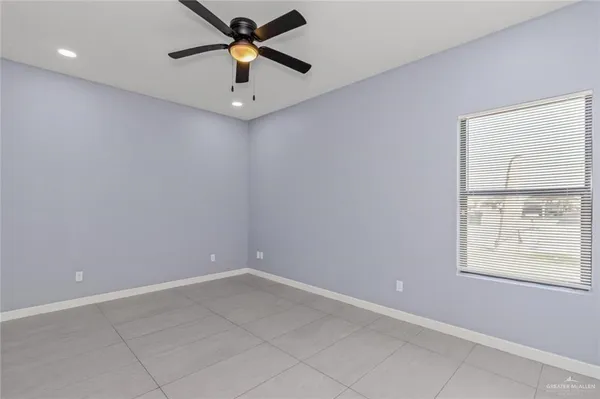 an empty room with a window and a fan