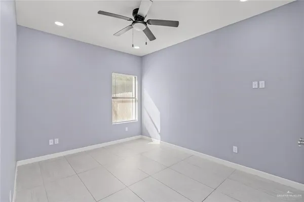 an empty room with a ceiling fan and window