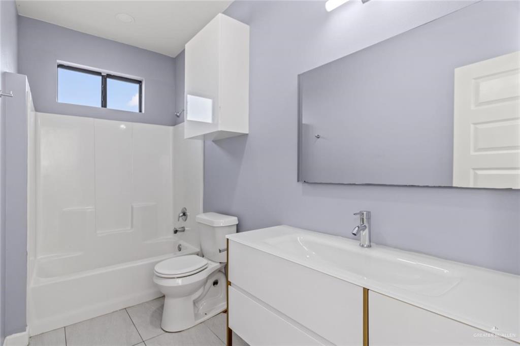 1200 West Harrison Avenue, Unit 2 Alton, TX 78573 - Photo 9 of 11 a bathroom with a toilet sink and mirror