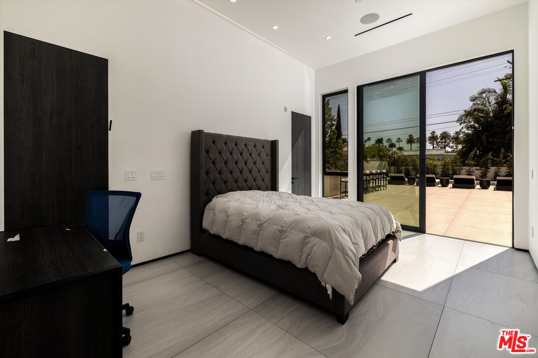 621 North Rodeo Drive Beverly Hills, CA 90210 - Photo 16 of 28 a bed sitting in a bedroom next to a window