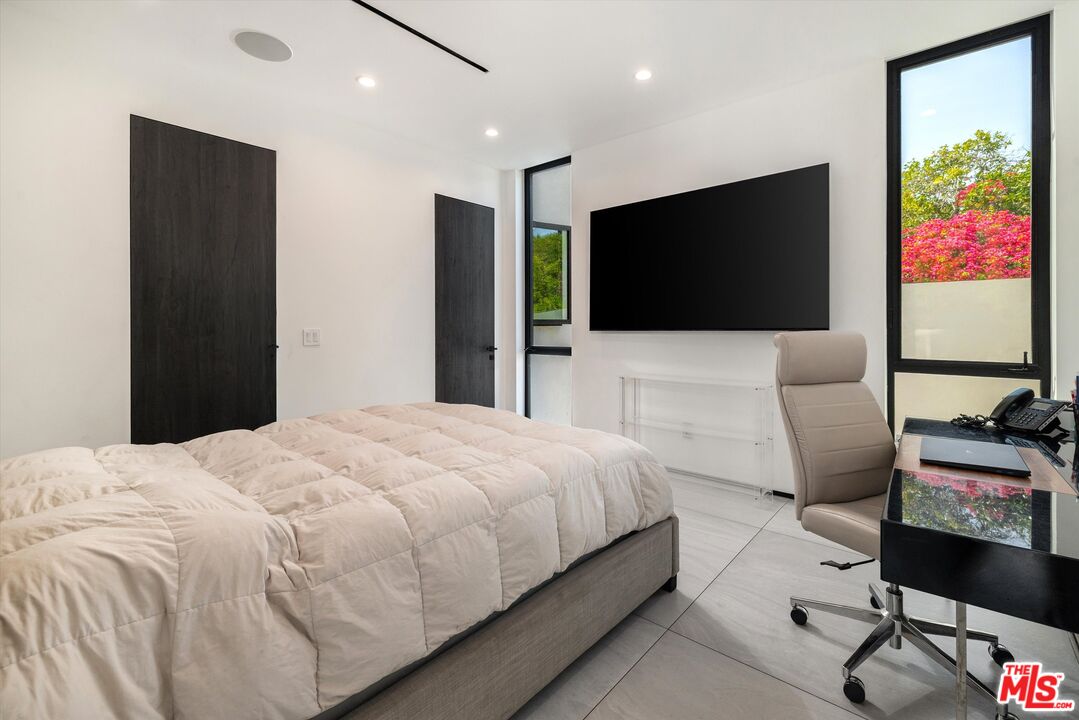 621 North Rodeo Drive Beverly Hills, CA 90210 - Photo 18 of 28 a bedroom with a bed and a flat screen tv