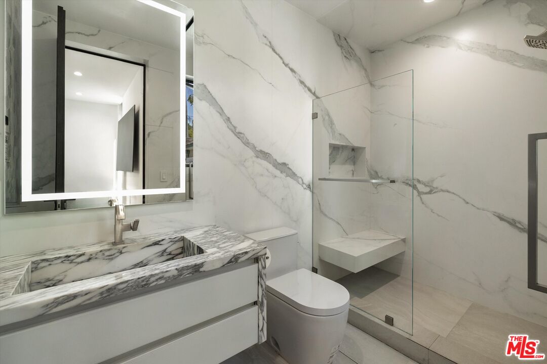 621 North Rodeo Drive Beverly Hills, CA 90210 - Photo 19 of 28 a bathroom with a granite countertop sink toilet and shower