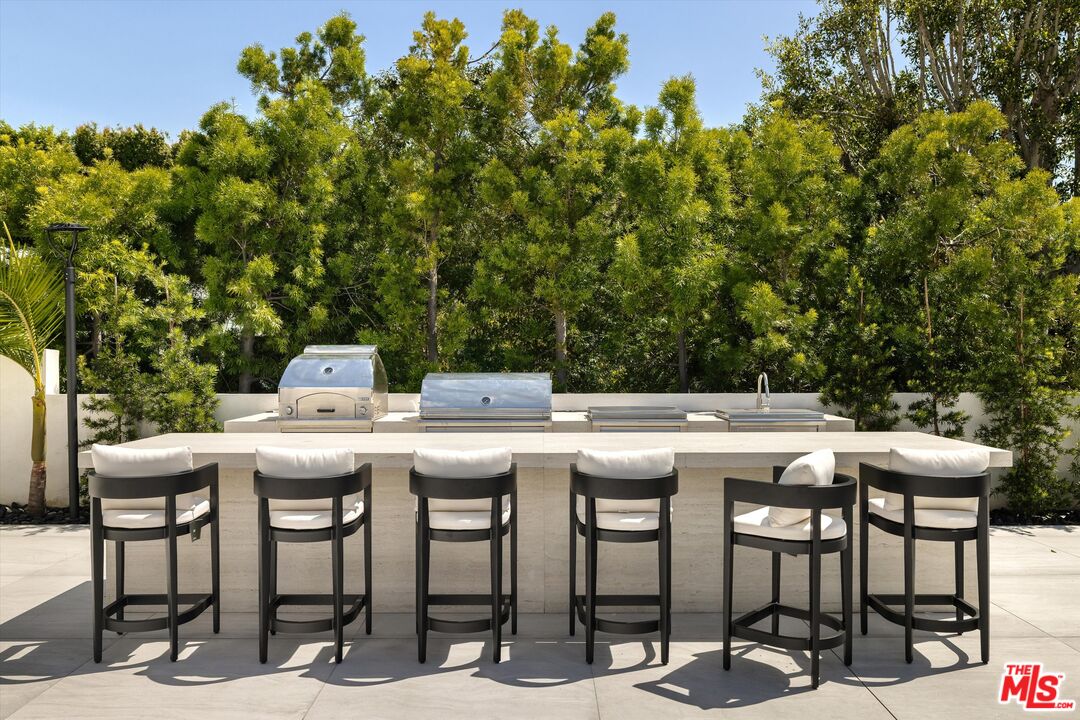 621 North Rodeo Drive Beverly Hills, CA 90210 - Photo 26 of 28 a patio with table and chairs