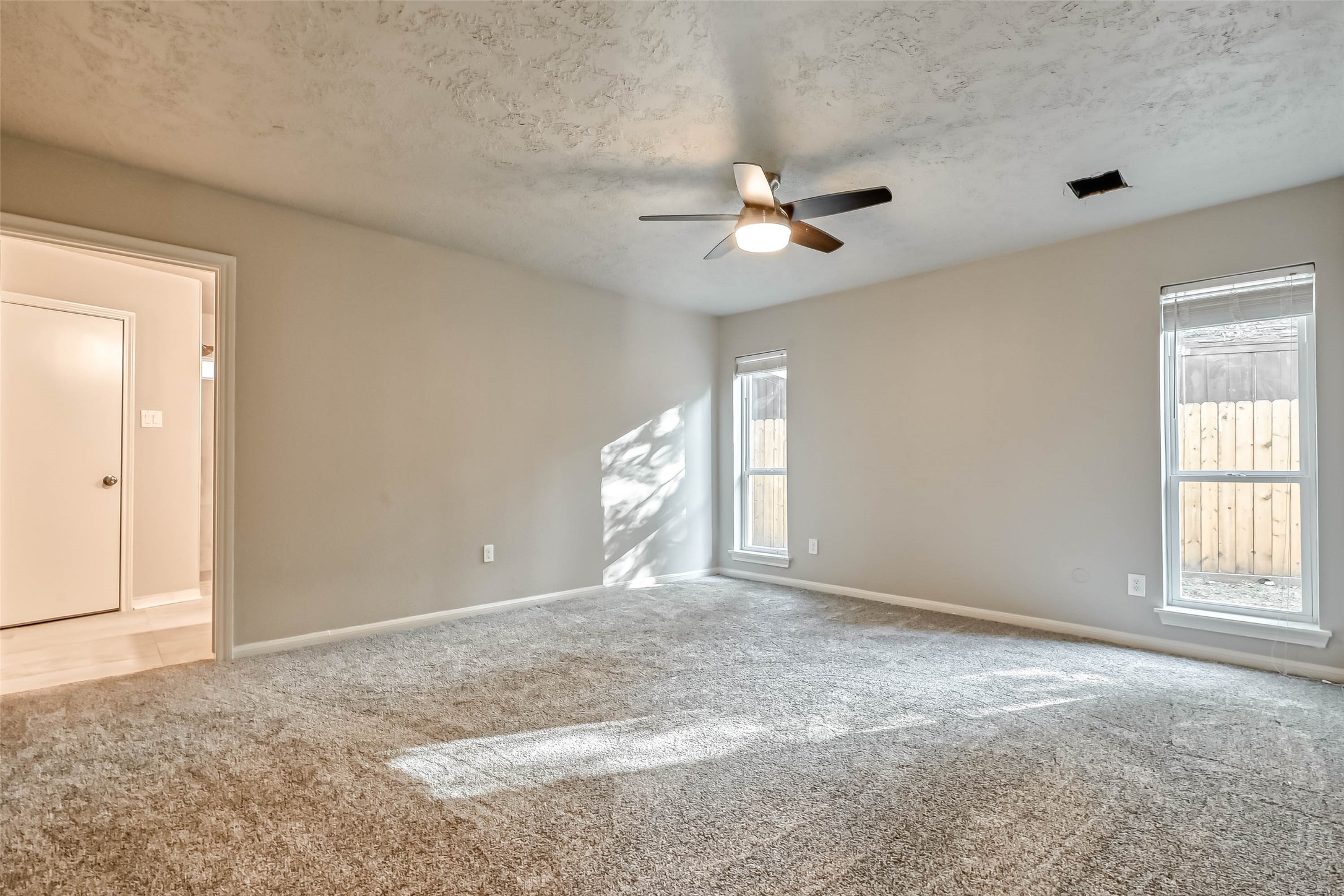 3615 Highfalls Drive Houston, TX 77068 - Photo 32 of 45 an empty room with windows and ceiling fan