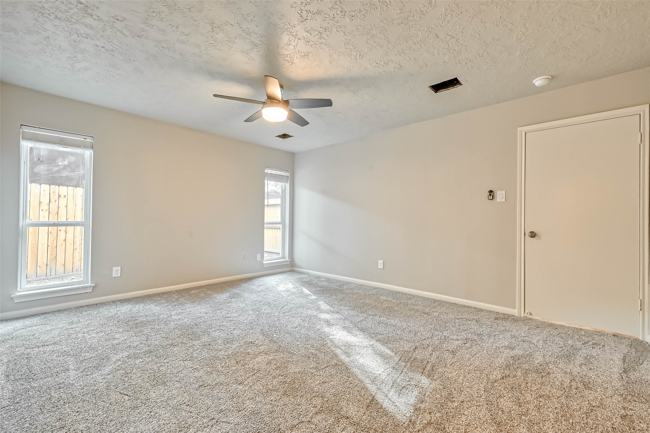 3615 Highfalls Drive Houston, TX 77068 - Photo 33 of 45 an empty room with chandelier fan and windows
