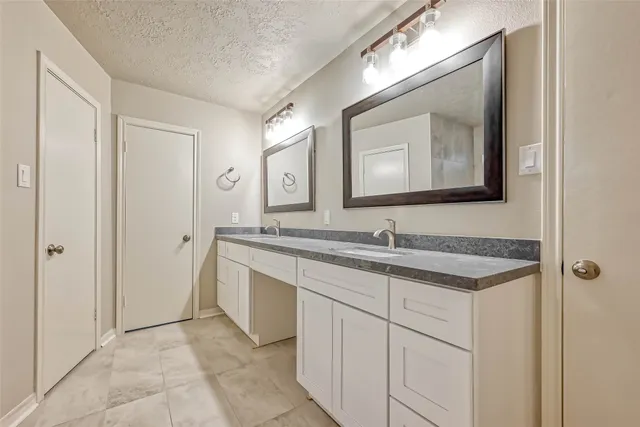 a bathroom with a granite countertop sink and a mirror