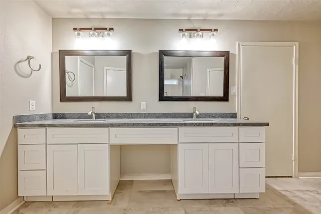 a bathroom with double sink and a mirror
