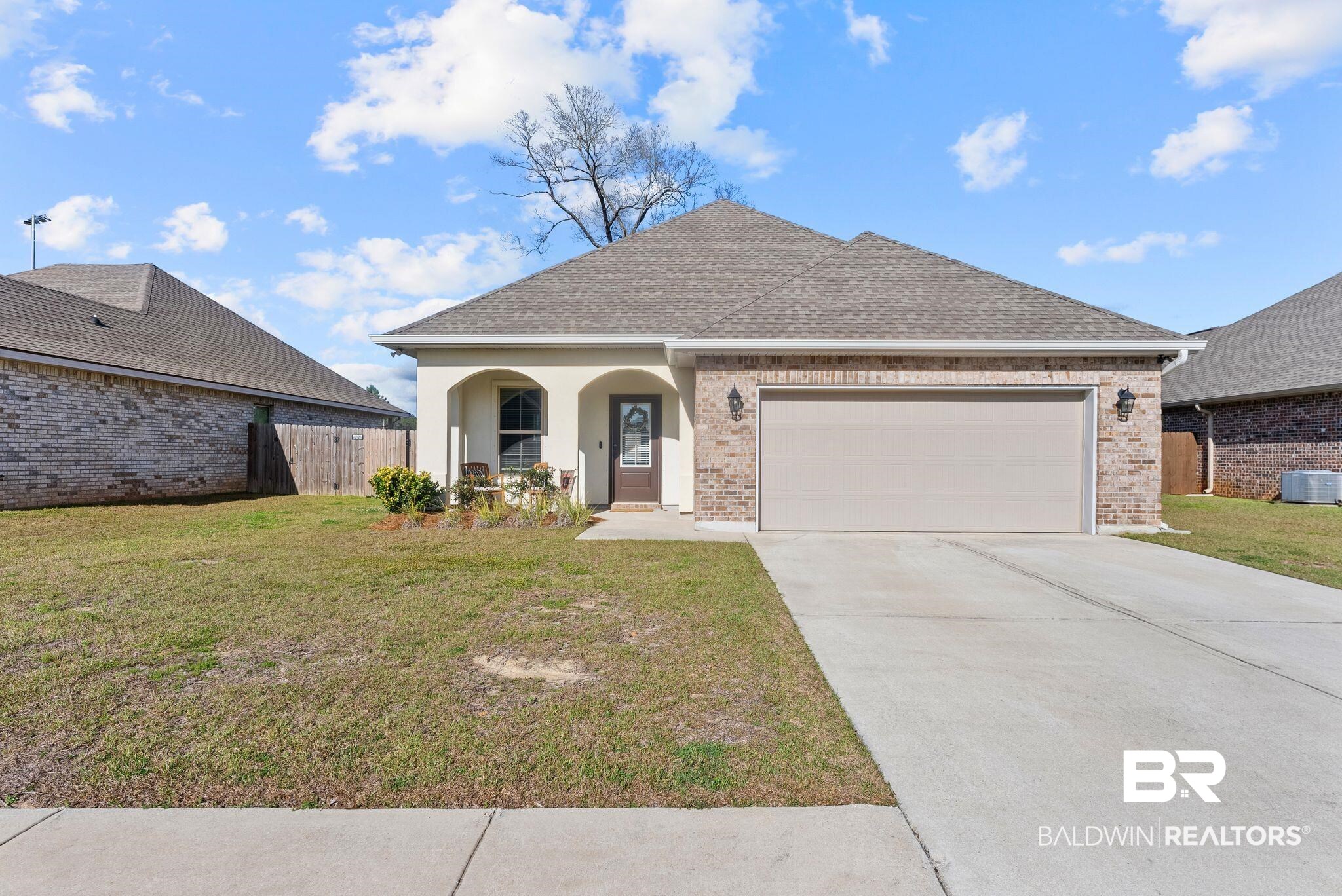 View of front of home with a garage, a porch, roof with shingles, concrete driveway, and brick siding