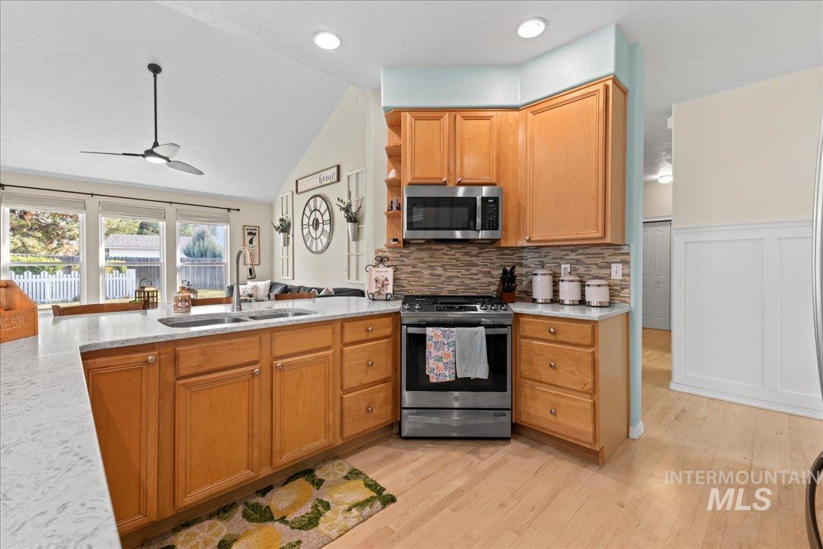 6326 North Talcrest Place Boise, ID 83713 - Photo 14 of 34 Kitchen with stainless steel appliances, open shelves, a ceiling fan, light stone counters, and lofted ceiling
