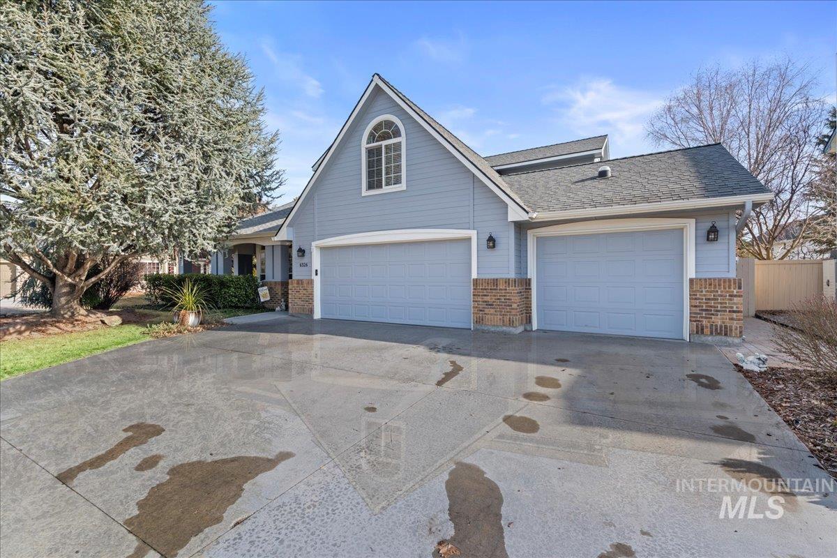 6326 North Talcrest Place Boise, ID 83713 - Photo 2 of 34 Traditional-style house featuring concrete driveway, brick siding, an attached garage, and roof with shingles