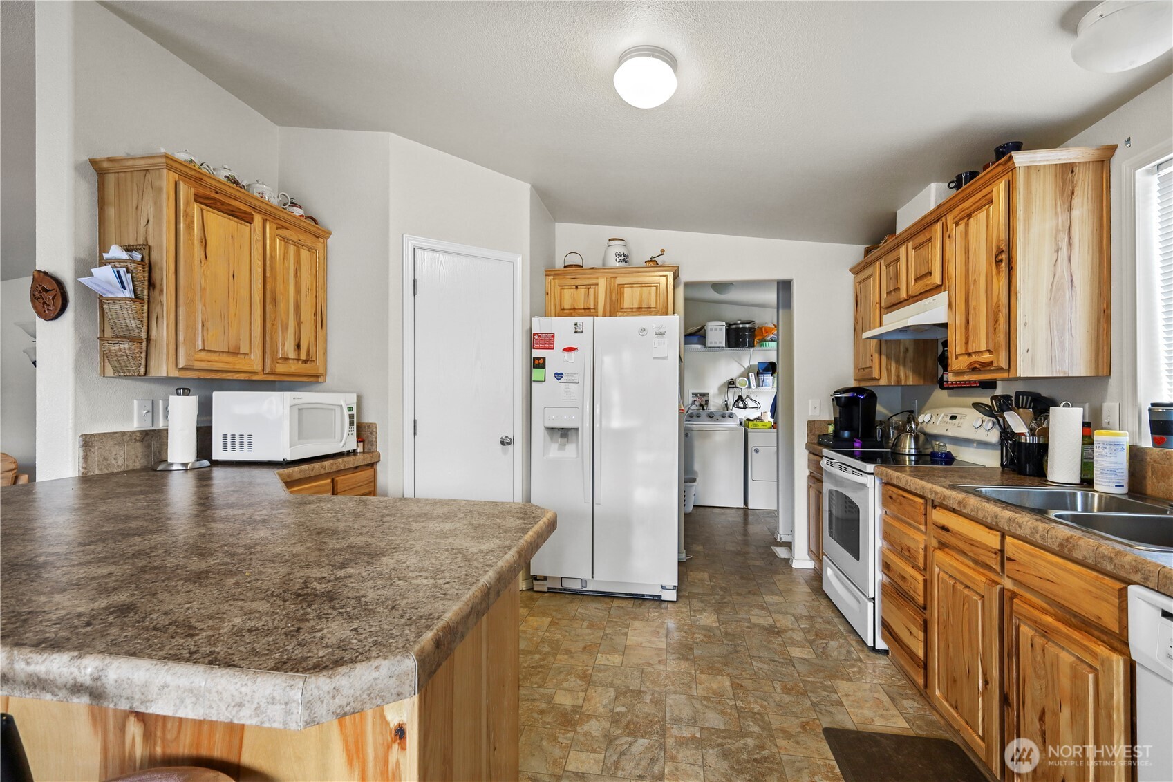 19206 99th Avenue East, Unit 48 Graham, WA 98338 - Photo 14 of 28 a kitchen with stainless steel appliances granite countertop a refrigerator a stove and a sink with wooden floor