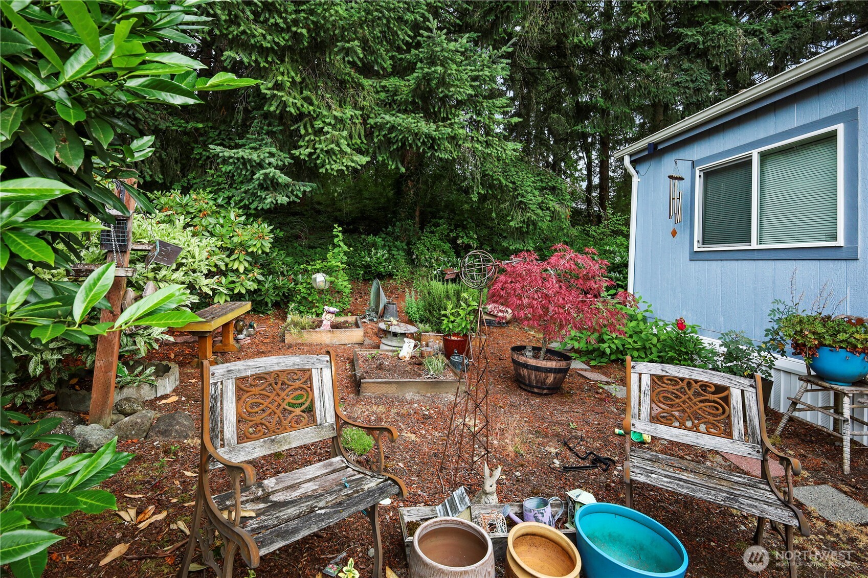 19206 99th Avenue East, Unit 48 Graham, WA 98338 - Photo 21 of 28 a view of a backyard with table and chairs potted plants