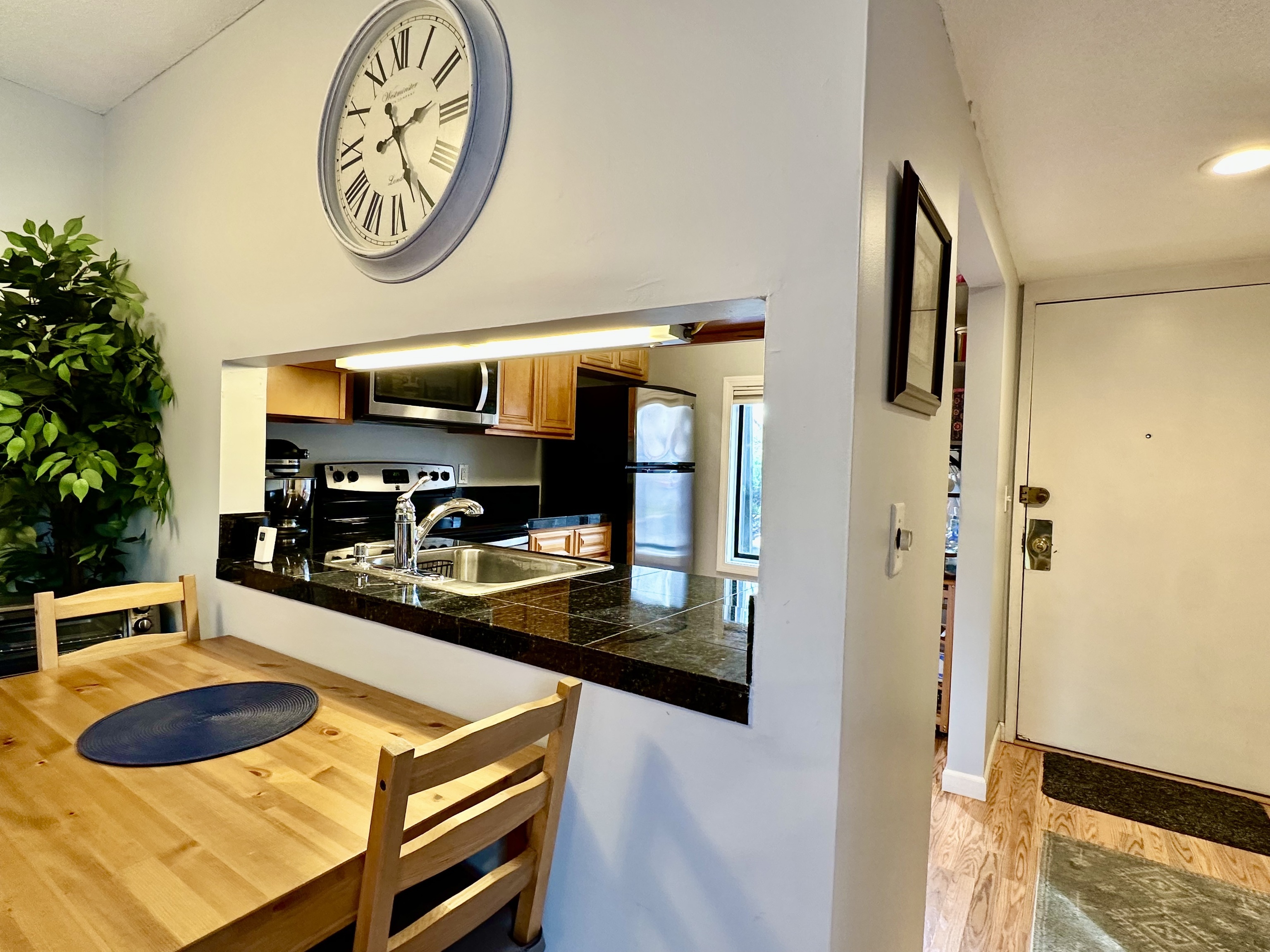 30 Orange Road, Unit 30 Middletown, CT 06457 - Photo 9 of 28 a kitchen with a refrigerator a stove top oven a clock and a potted plant