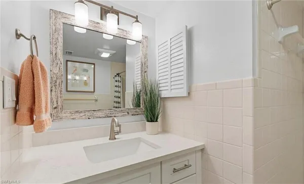 a bathroom with a sink vanity and mirror