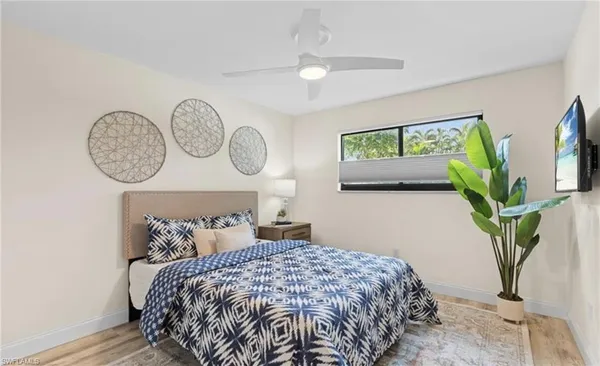 a bedroom with bed and a potted plant