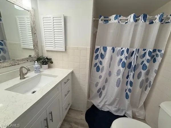 a bathroom with a sink and mirror with toilet