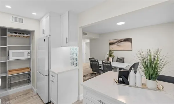 a kitchen with a refrigerator and potted plant