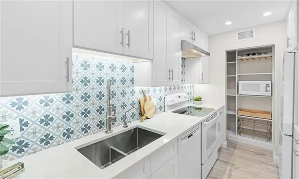 a kitchen with stainless steel appliances kitchen island granite countertop a sink and a stove