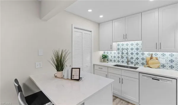 a kitchen with granite countertop white cabinets and a potted plant