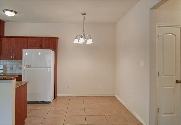 a view of a kitchen with refrigerator and wooden floor