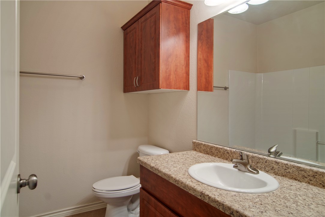 4454 Reveille Road College Station, TX 77845 - Photo 9 of 13 a bathroom with a granite countertop sink toilet and a mirror
