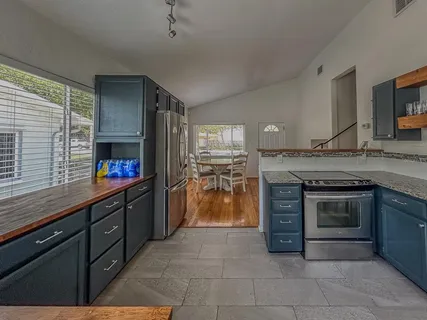 a kitchen with stainless steel appliances granite countertop a stove a sink and a microwave