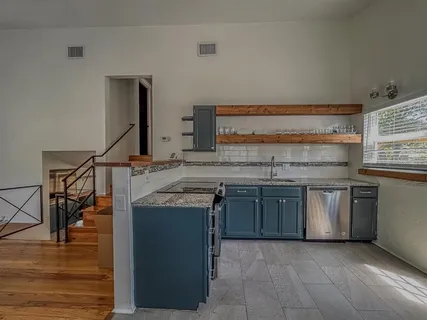 a kitchen with stainless steel appliances granite countertop a sink and a stove