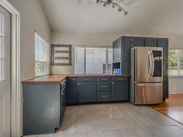 a kitchen with a refrigerator and a stove top oven
