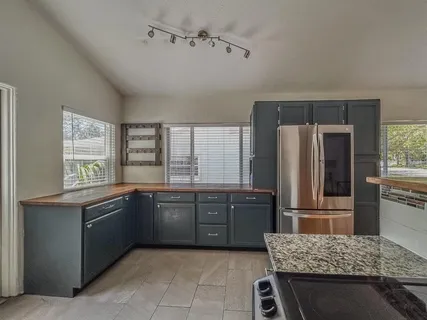 a kitchen with granite countertop a refrigerator and a sink