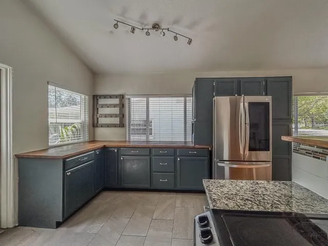 a kitchen with granite countertop a refrigerator and a sink